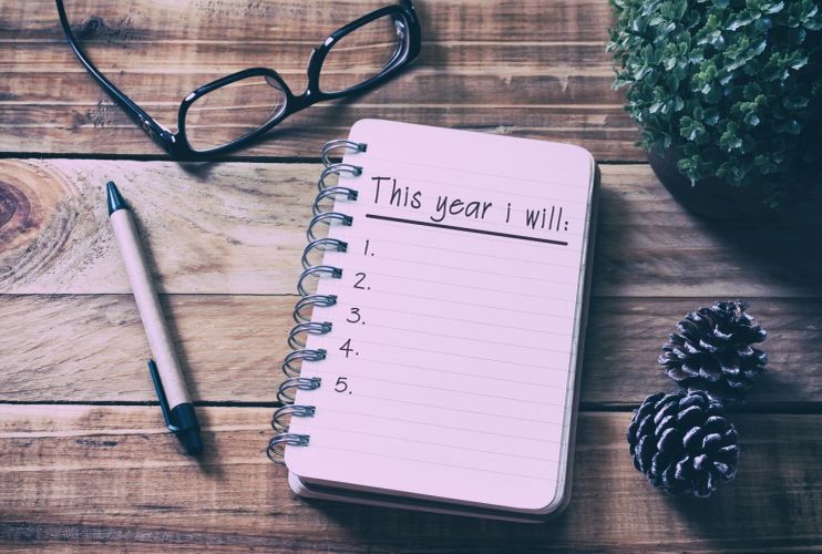Woman writing goals in notebook